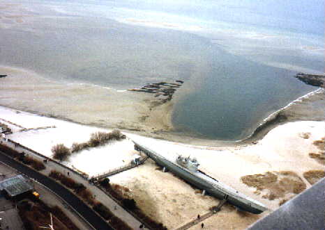 Im oberen Teil des Bildes: Wasser, dann Sand; aufgeständert das U-Boot...