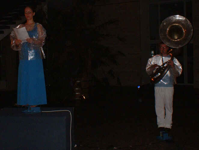 Foto: Eine Sängerin und ein Susaphonist stehen auf je eine sich drehenden Plattform.